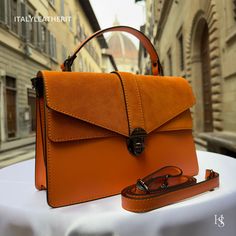 This bag has been made of the best genuine leather by local master crafters of Florence in Italy, designed for women who only accept premium Italian quality and luxury leather bags and modern Italian fashion. . Sizes: Width: 29cm/10.6 inch Height: 19cm/7.4 inch Depth: 7 cm/3.9 inch The story of this bag :  In the heart of Florence, Italy, where the legacy of art and craftsmanship intertwines with the modern world, a master artisan named Sofia was crafting a piece of pure elegance - a Luxury Leather Bag like no other. This red leather bag wasn't just a fashion accessory; it was an embodiment of Italy's rich heritage in leatherwork, meticulously handmade with genuine leather. Sofia's dedication to her craft was unparalleled, and her creations were nothing short of masterpieces. Her workshop Workwear Flap Bag With Textured Leather, Luxury Formal Vegetable Tanned Leather Shoulder Bag, Luxury Vegetable Tanned Leather Satchel, Leather Flap Bag With Smooth Grain For Daily Use, Modern Leather Flap Bag With Smooth Grain, Daily Use Leather Flap Bag With Smooth Grain, Luxury Cognac Flap Bag For Daily Use, Modern Orange Leather Satchel, Chic Orange Leather Satchel