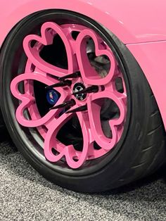 a pink car with hearts painted on it's front wheel rims and spokes