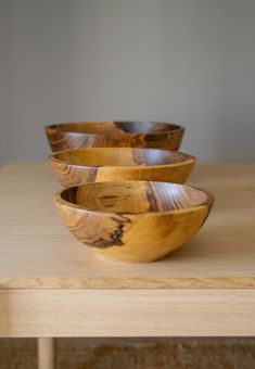 three wooden bowls sitting on top of a table