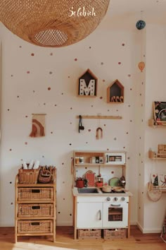 a white kitchen with wooden shelves and baskets on the wall next to an open door