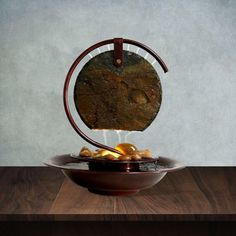 a bowl that has some rocks in it on a wooden table next to a wall