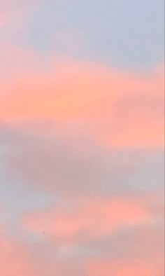 an airplane is flying high in the sky at sunset or dawn with pink clouds behind it