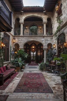 the inside of a large building with lots of plants and couches in front of it