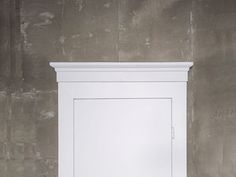 an empty white cabinet against a wall