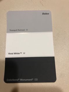 a pantone color swatch with white and gray colors on it, sitting on top of a table