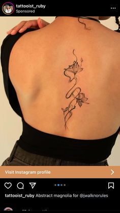 the back of a woman's shoulder with tattoos on her upper and lower back