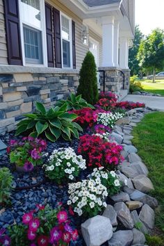 flowers and rocks in front of a house