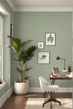 a home office with green walls and pictures on the wall above the desk, along with a white chair