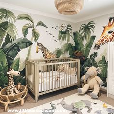 a baby's room with giraffes and palm trees on the wall