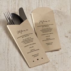 a table setting with silverware and menu cards