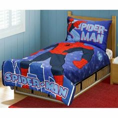 a bed with spider man comforter and pillows on it in a room that has blue walls