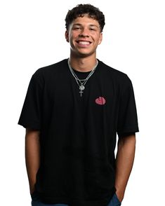 a young man wearing a black shirt and smiling