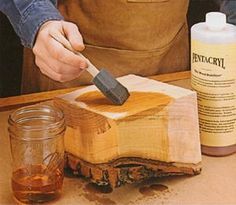 a person using a hammer to cut wood with a wooden block in front of them