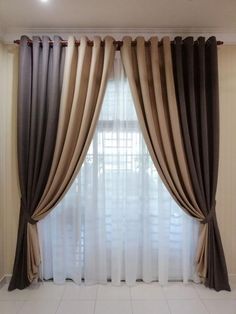 a living room with white tile flooring and large window covered in beige drapes