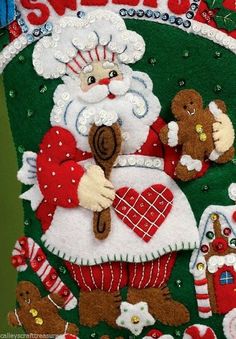 a christmas stocking with santa holding a teddy bear and gingerbreads on it