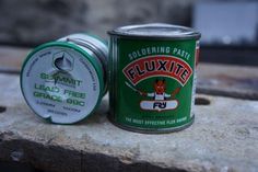 a can of ploxite sitting on top of a stone slab next to a tin