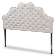 an upholstered headboard with metal legs and studding on the back side