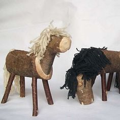 two wooden horses are standing next to each other on a white background, one is black and the other has blonde hair