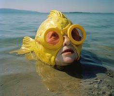 a man wearing goggles and a yellow fish mask in the water with his eyes closed