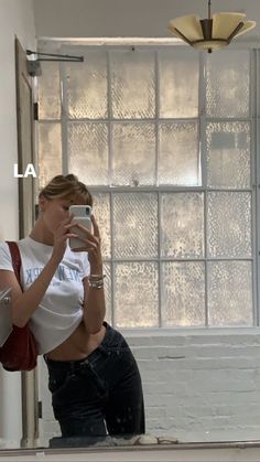 a woman is taking a selfie in front of a mirror with her cell phone