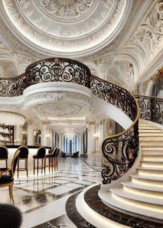 a spiral staircase in the middle of a room with marble flooring and white walls