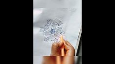 someone is drawing with colored pencils and paper on a piece of white paper that they are holding in their hands