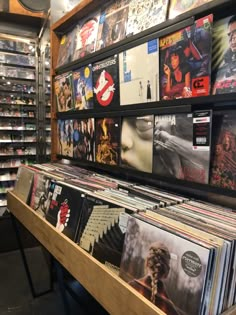 an assortment of records are on display in a record store with shelves full of cds