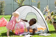 Two children playing inside the Deryan Beachtent. Garden Shelter, Pop Up Beach Tent, Beach Tent, Travel Cot, Going To The Beach, Cots, Beach Camping, Beach Fun, Outdoor Gear