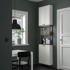 a room with a desk, chair and bookshelf in front of a window