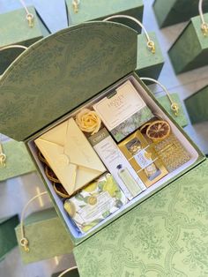 an open green box filled with lots of different types of cards and envelopes on top of a table