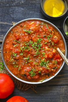 a pan filled with tomato sauce next to tomatoes