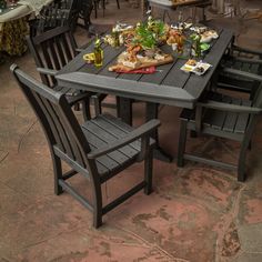 an outdoor table and chairs with food on it