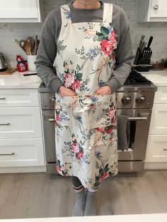 a woman standing in a kitchen wearing an apron