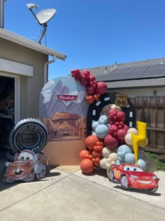 cars and balloons are displayed in front of a house