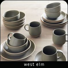 a table topped with plates and cups on top of a wooden table