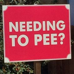 a red and white sign that says, needing to pee?