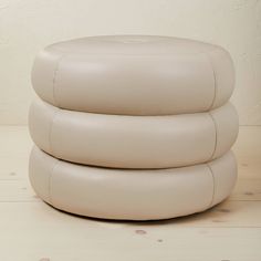 three white leather stools stacked on top of each other