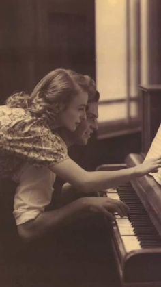 an old black and white photo of a woman playing the piano