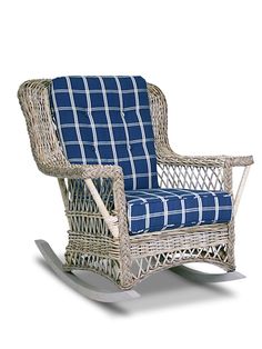 a wicker rocking chair with blue and white checkered seat cover on the back