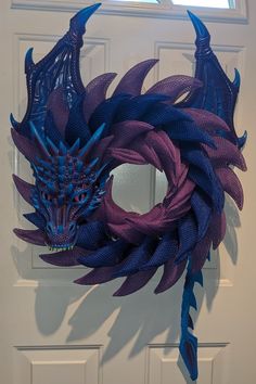 Perfect for the dragon lover! Wreath features blue and purple scales with matching wings, tail, and mask. Wreath measures approximately 26" in length. **If you are looking for something custom, just ask! I can work with you to make the perfect dragon. Fire can also be added for an additional fee.** Dragon Wreath, Hobby Room Design, Maple Shade, Wish Box, Dragon Fire, Purple Dragon, Dragon Lover, Hobby Room, Wreath Designs