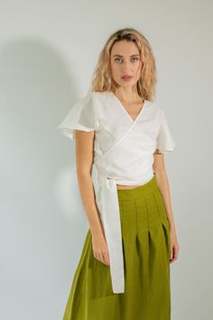 The CADIZ linen summer wrap top is a great piece that will enhance your silhouette. Its flutter sleeves add a delicate touch of femininity. This top pairs perfectly with both shorts and skirts, making it a great addition to your wardrobe. * Linen cropped wrap top with a crossover front and v-neckline. * Ties at the waist and darts at the bustline adjust for a body-conforming fit. * Slightly flutter sleeves. * Fits all body types. * Made from medium-weight (205 G/M²) stonewashed OEKO-TEX 100 standards certified linen fabric. Wrap Top Designs, Wrap Top Pattern Free, Wrap Top Pattern, Linen Wrap Top, White Wrap Top, White Summer Tops, Crossover Top, Linen Crop Top, Blouse Summer