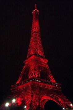 the eiffel tower lit up in red at night