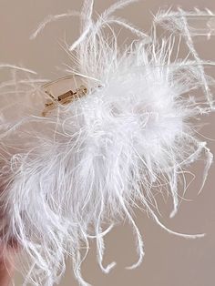 a person holding something with white feathers on it