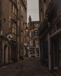 an empty street with old buildings on both sides and a clock tower in the distance