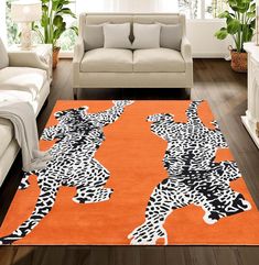 a living room with white furniture and an orange rug that has zebras on it