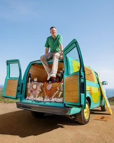 a man sitting on the back of a blue truck