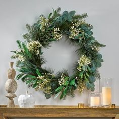 a wreath is hanging on the wall next to candles