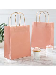 there are cupcakes in the paper bags next to each other on the table