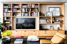 a living room filled with furniture and a flat screen tv on top of a wooden shelf