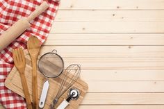 various kitchen utensils are laid out on a cutting board next to a checkered cloth